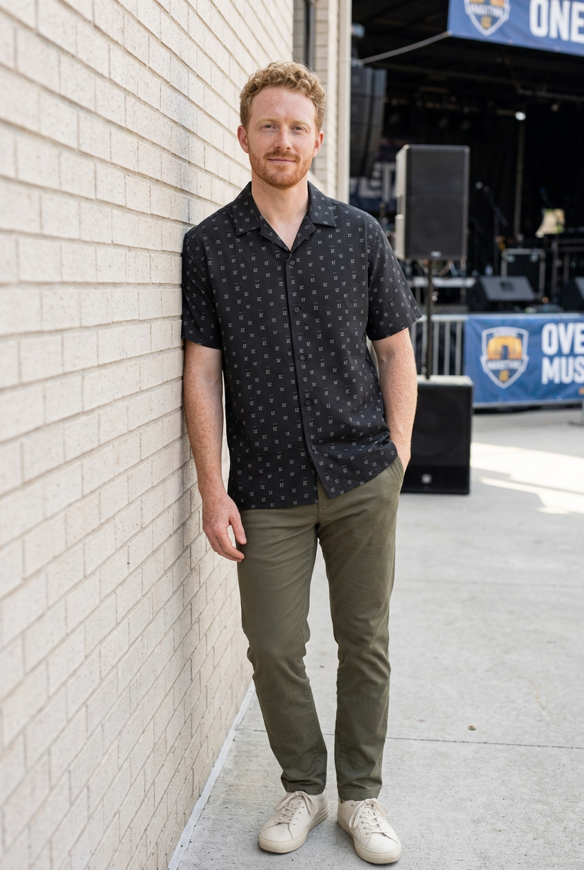 White model leaning against a wall at an open-air music venue
